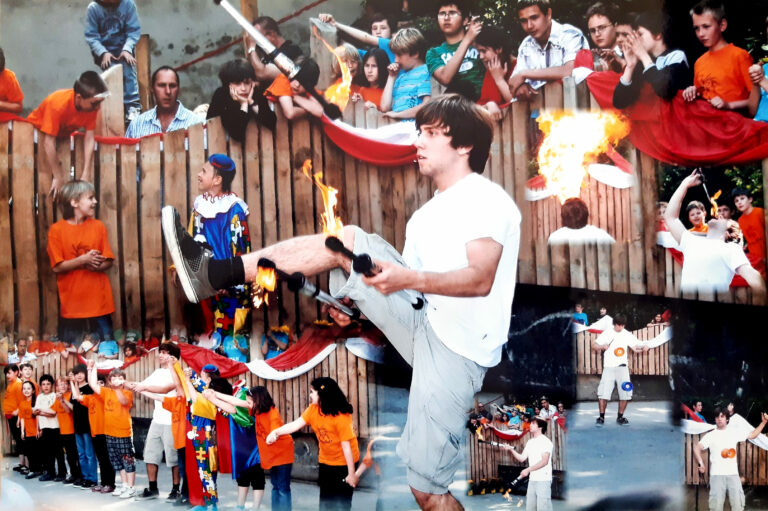 Bastian juggles fire clubs, spits fire and plays diabolo at a circus performance at a school.